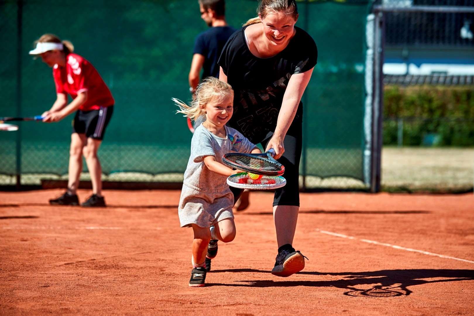 mor-og-datter-loeber-med-tennisbold